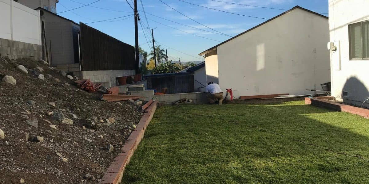 Old leaning fence with damaged and missing boards